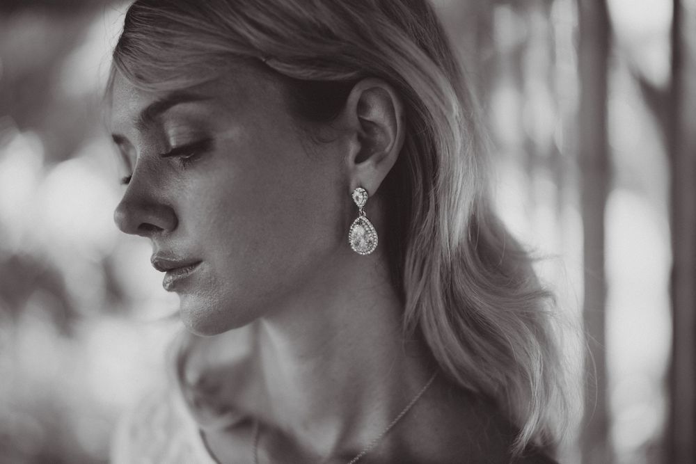 Side profile portrait of a bride in black and white with elegant jewelry.