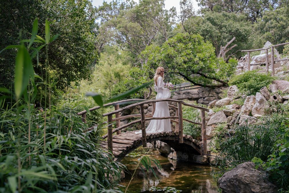 Stone archway surrounded by lush greenery creates romantic garden atmosphere.