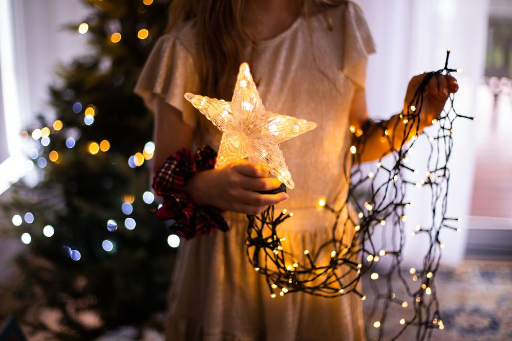 Glowing star-shaped holiday lights create a warm, festive ambiance against a dark background.