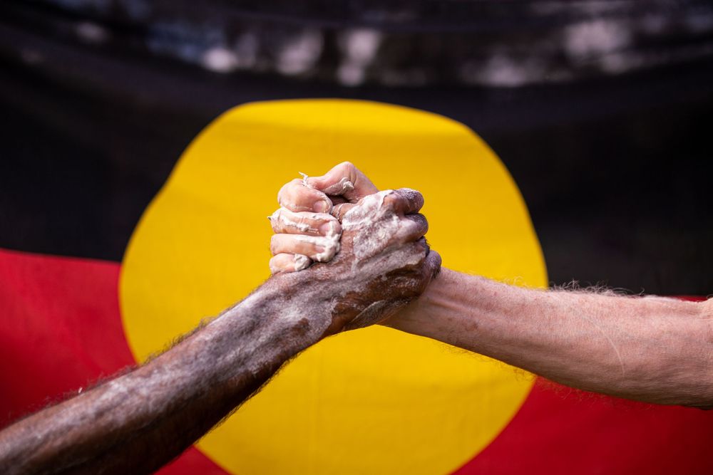 Two people arm wrestling in a competitive match with a bright yellow and red background.
