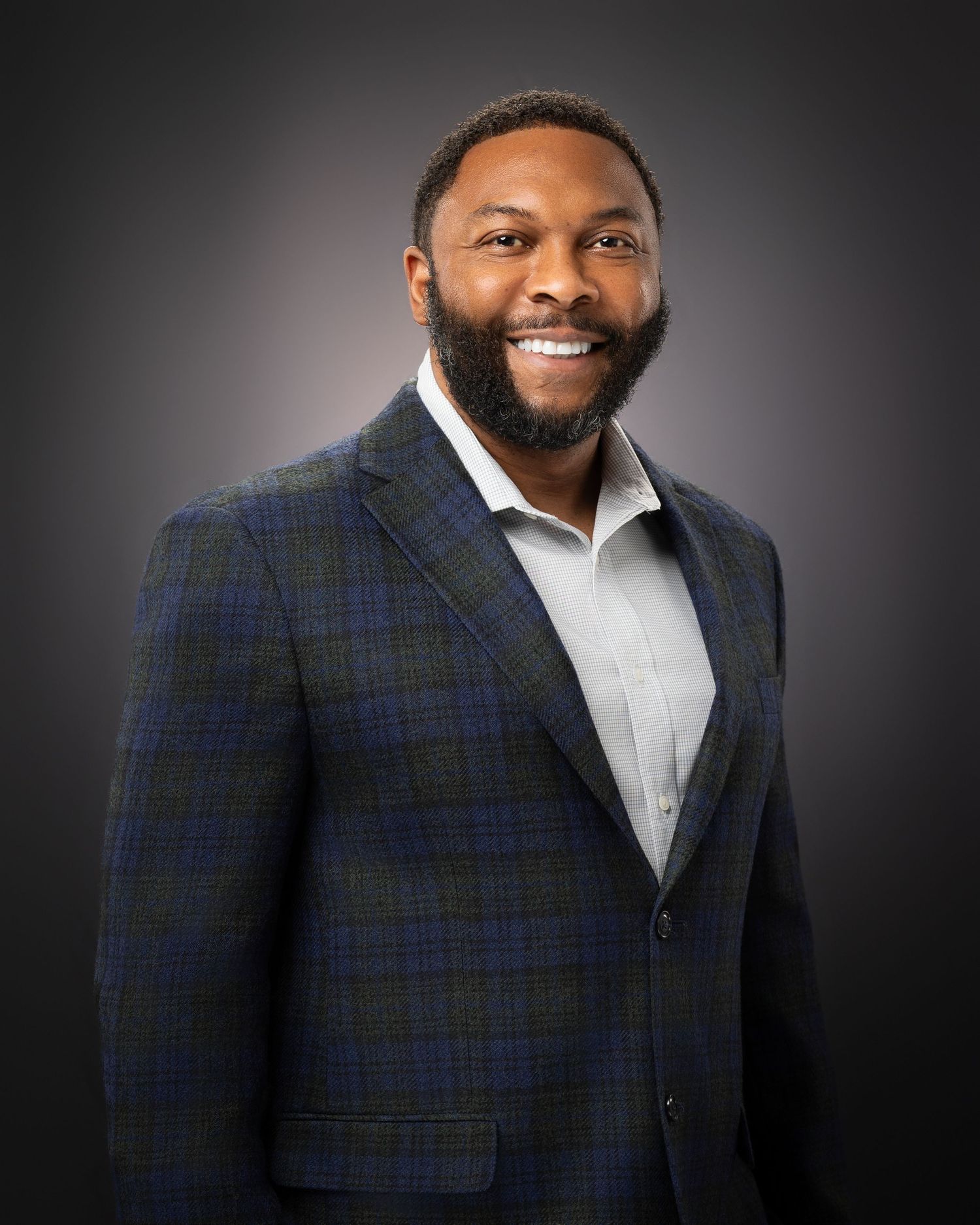 Professional headshot of an individual with confident expression, clean lighting, and neutral background.