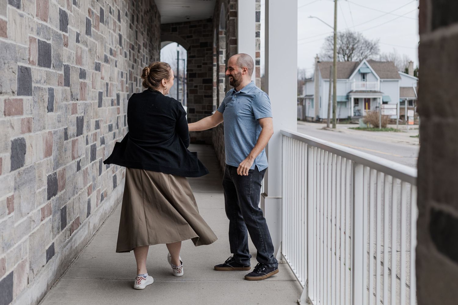 People walking on a porch with stone walls in a sequence of connected photos showing different angles and moments.