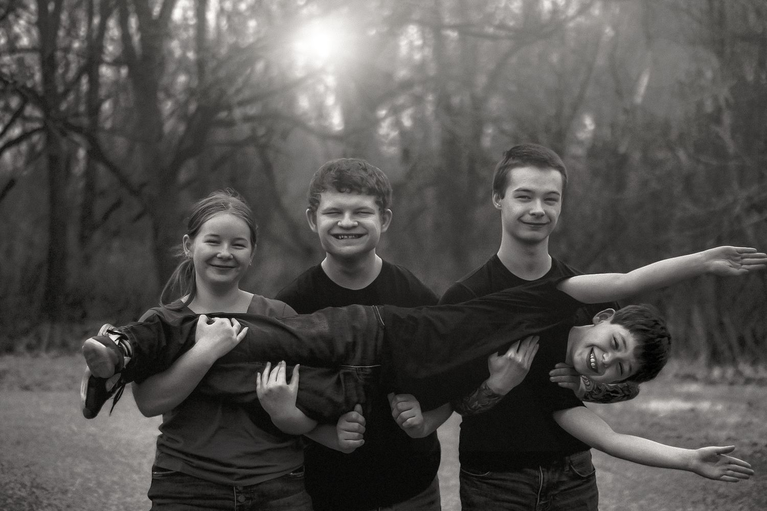 Three black and white photographs show children playing and posing outdoors in a natural wooded setting.