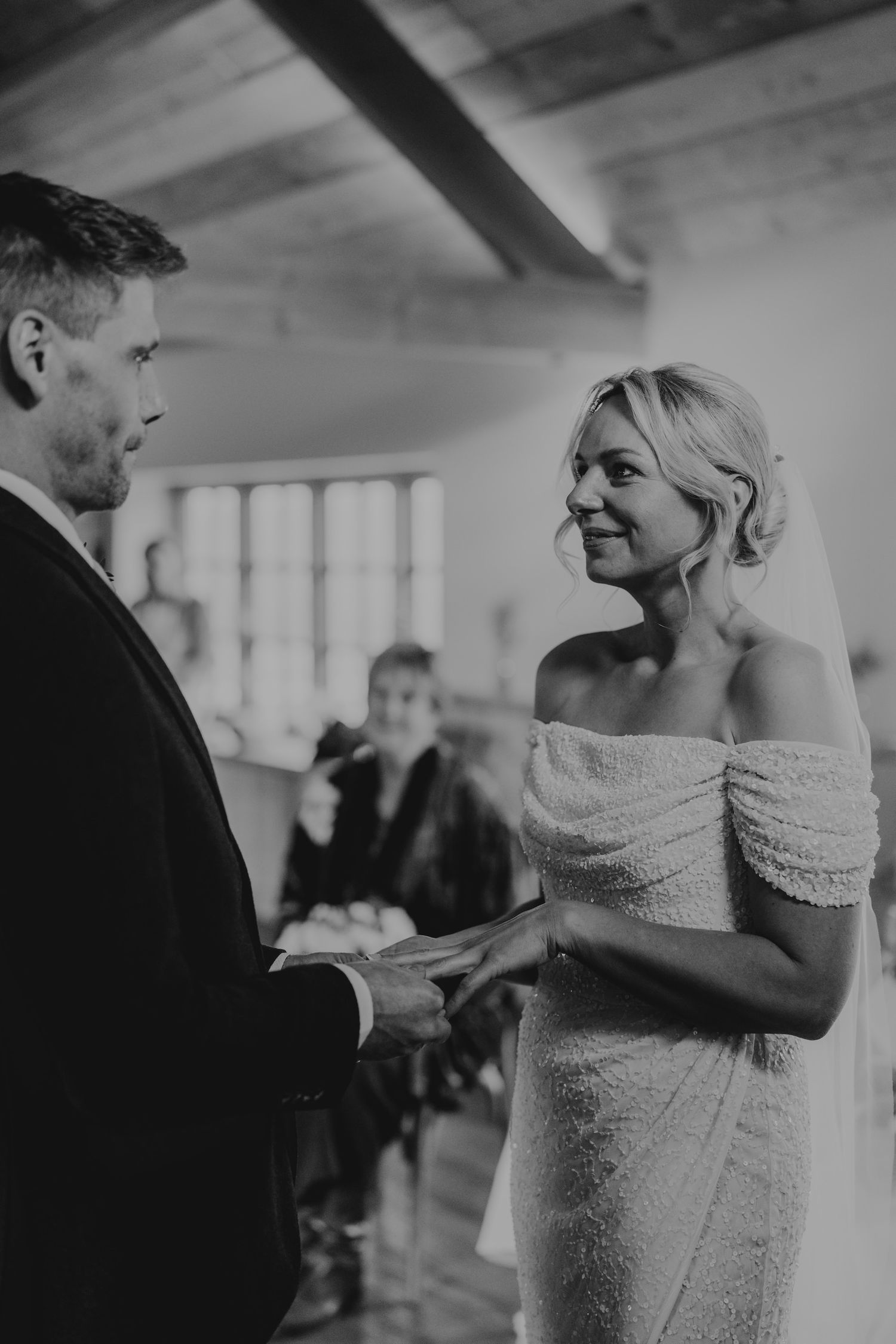 Elegant wedding couple shares a tender moment in a rustic wooden venue.