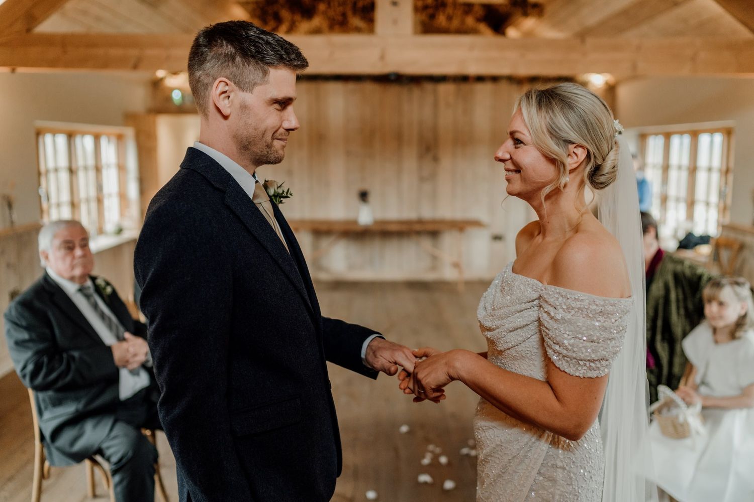 Romantic wedding ceremony unfolds in sunlit wooden barn setting.