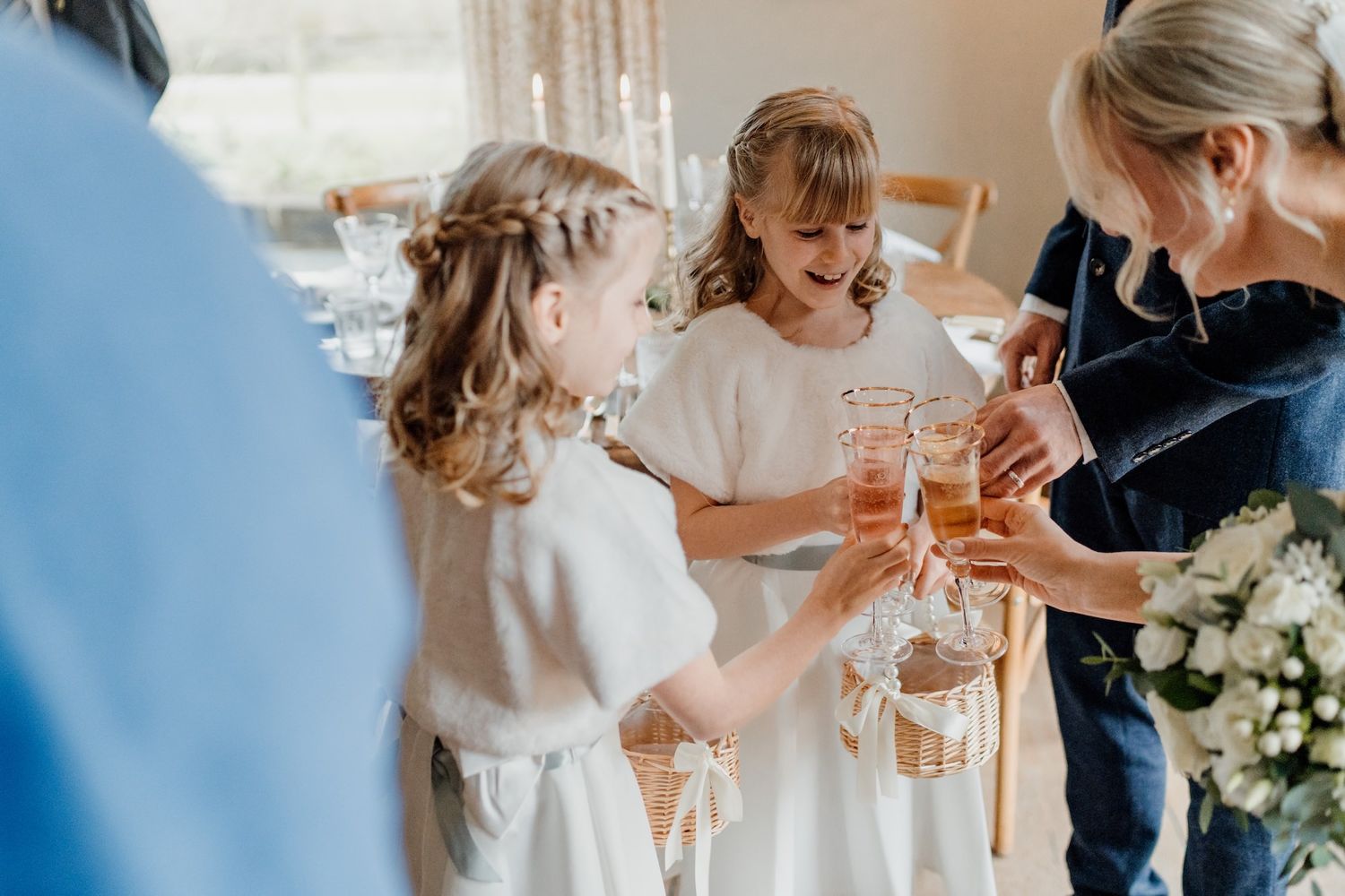 Wedding party toasting with champagne glasses in natural light.