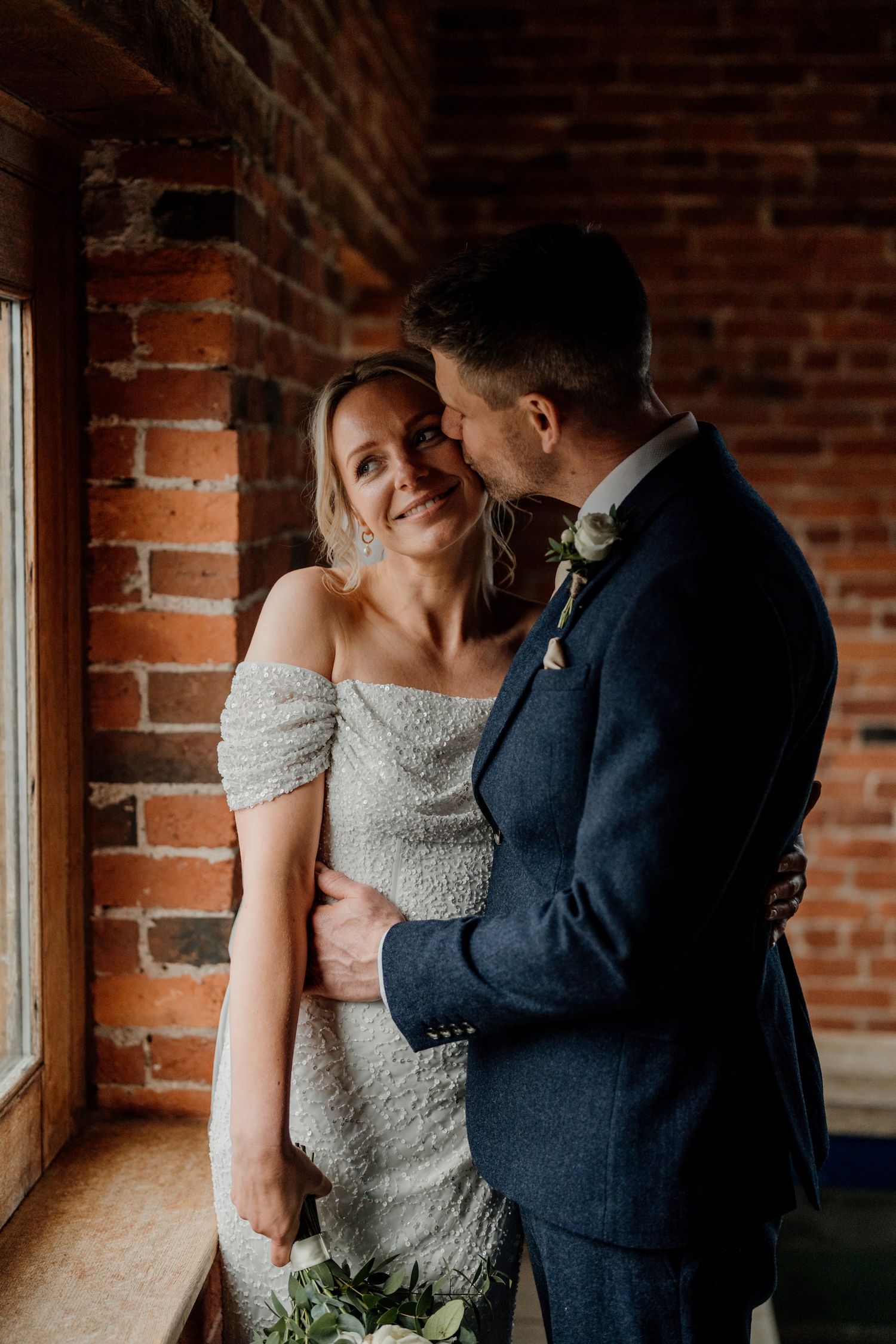 A series of intimate moments between newlyweds captured against a rustic brick wall backdrop during their wedding celebration.
