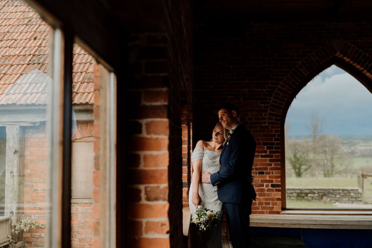 Brick archways frame architectural details in rustic building interior.