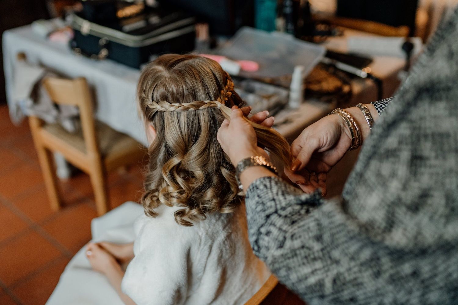 Wedding day hairstyling detail shot with soft lighting and delicate touches.