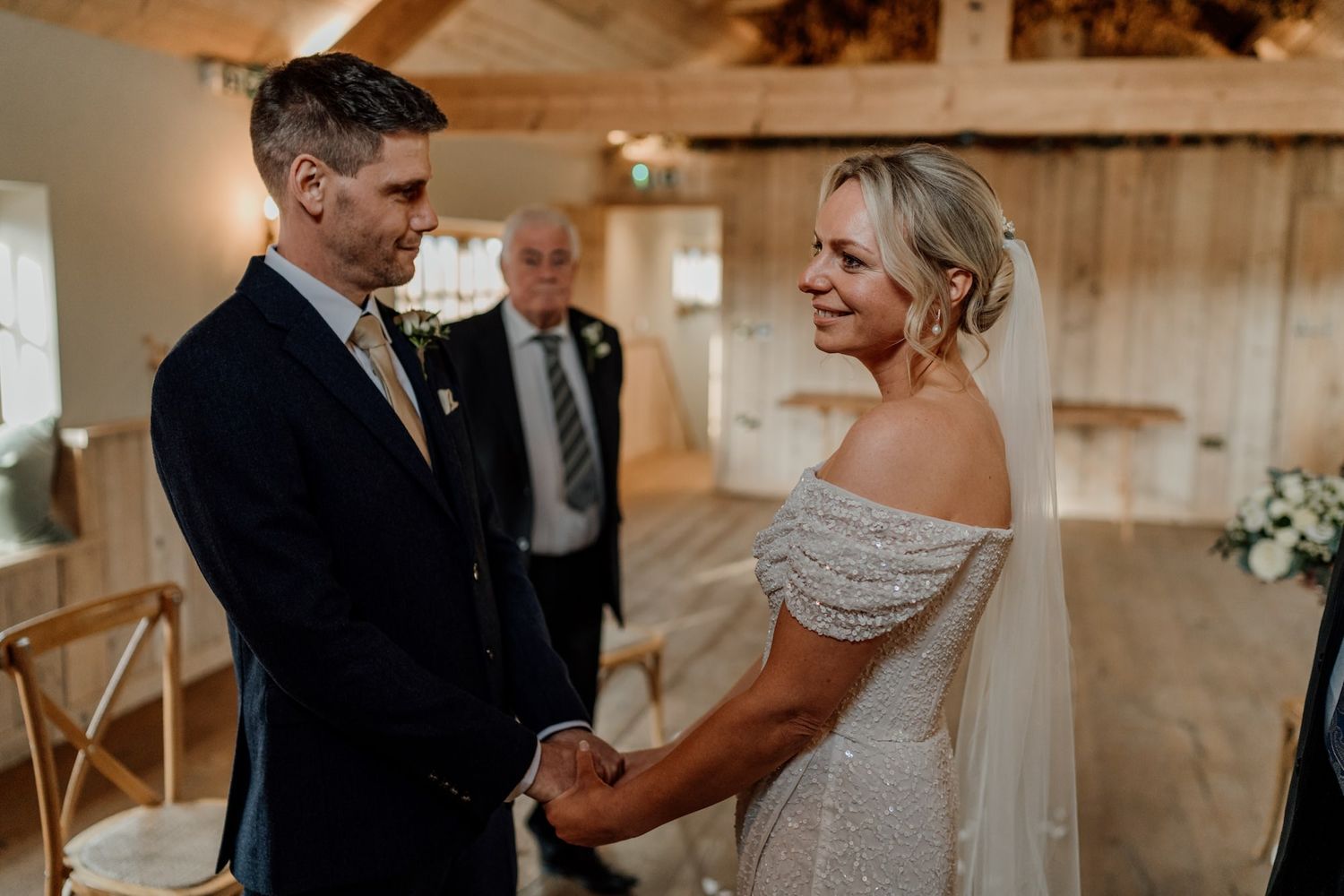 Intimate wedding moment captured in a rustic wooden venue with natural lighting.