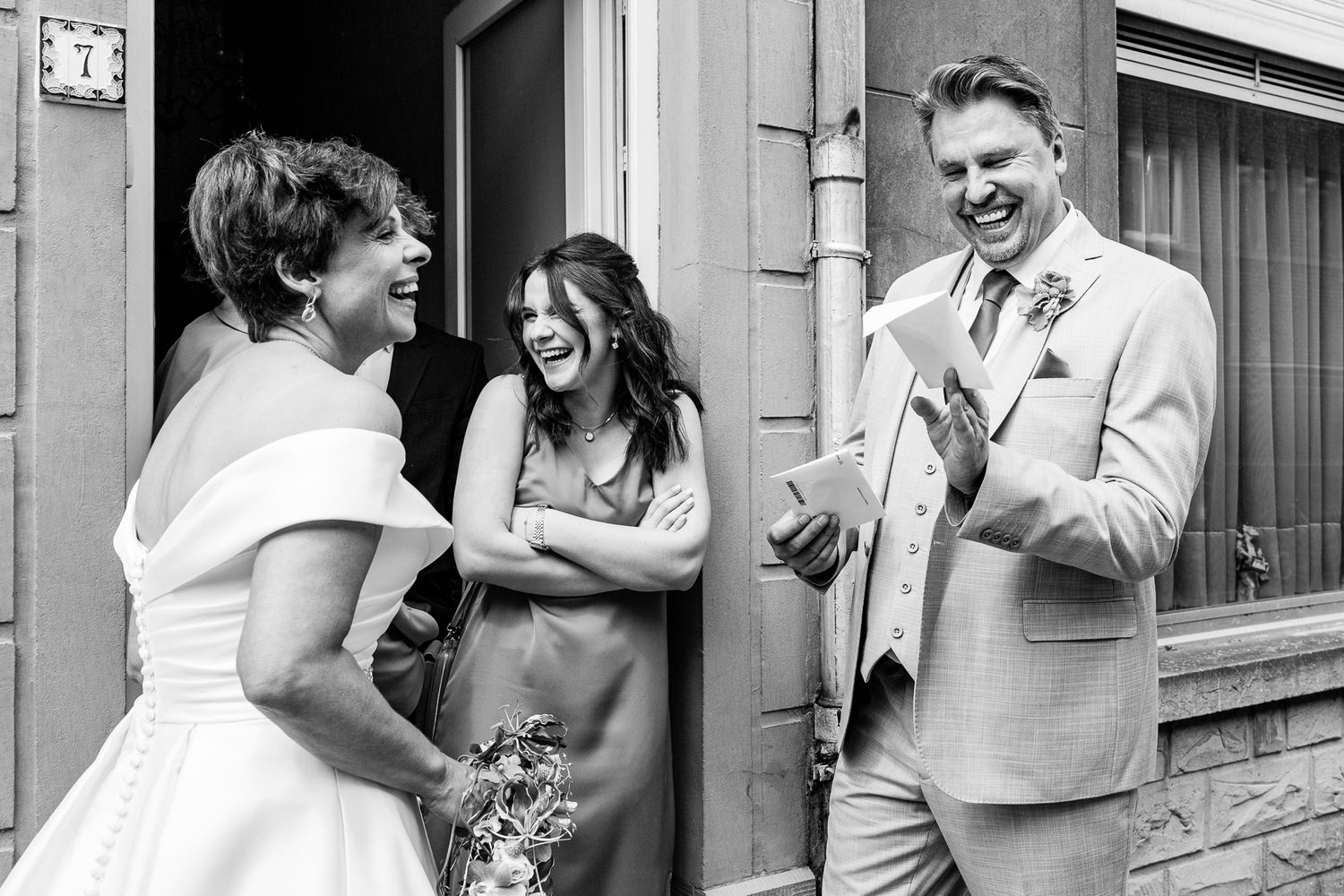 A couple in formal wedding attire share intimate moments against a rustic brick wall background.