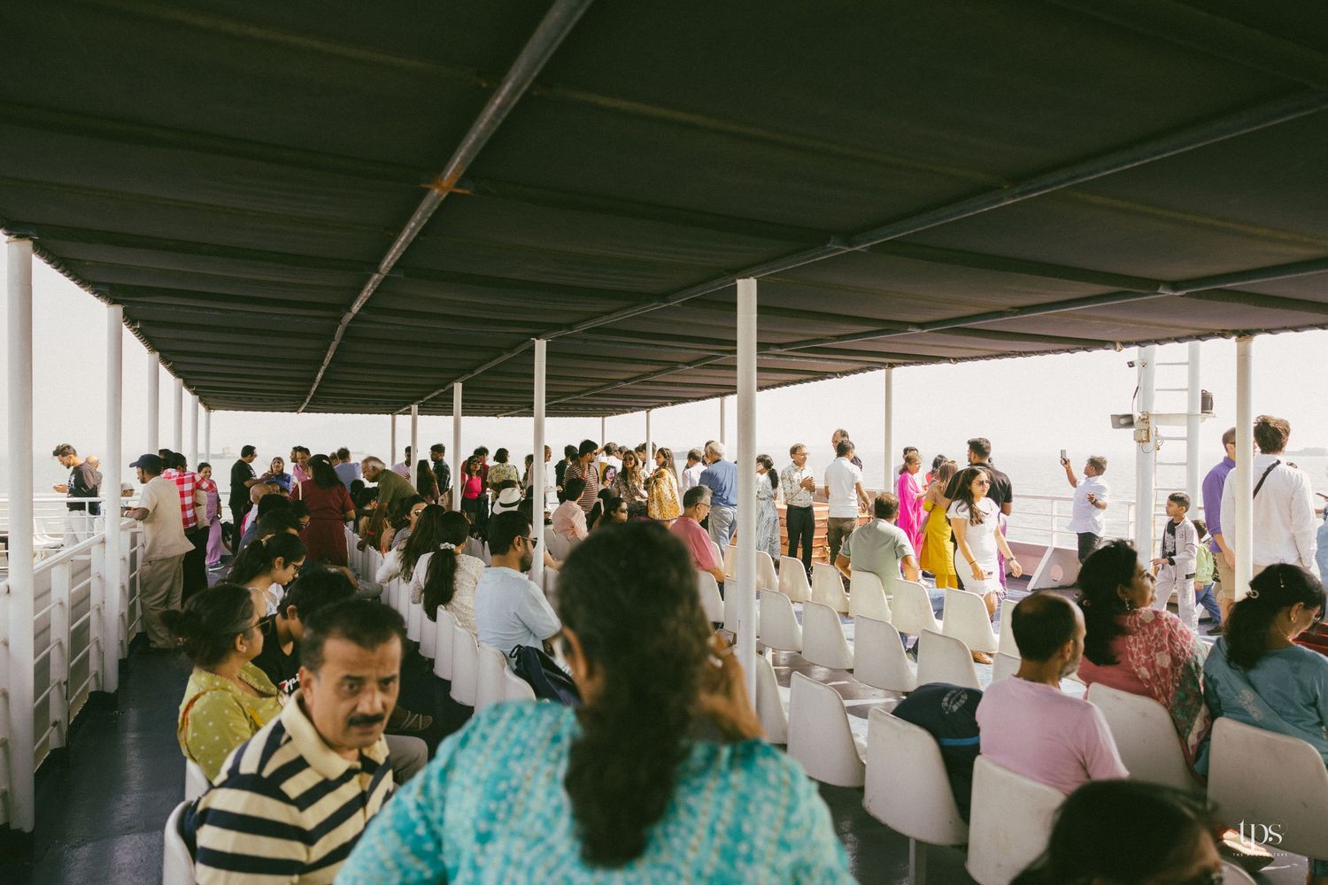Crowd mingling under a covered outdoor venue space.