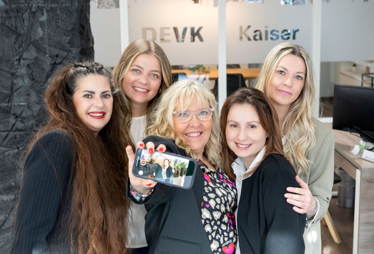 Ein Foto, das wie ein selfie aufgenommen wurde von einer Gruppe von Frauen. Die Frau in der Mitte hält das Handy hoch und alle lachen rein.