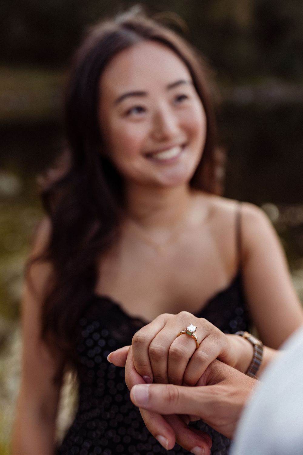 Close-up shot of hands touching during an intimate moment outdoors.