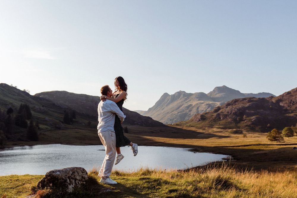 A joyful moment captured against a backdrop of mountains and a serene lake in the highlands.