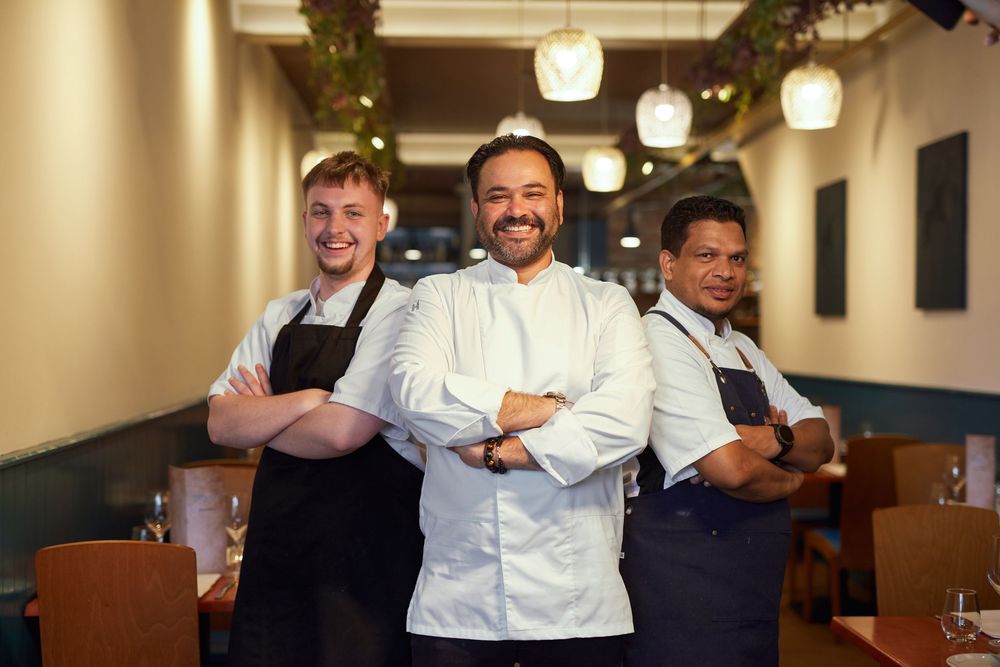 Restaurant team members in uniform sharing a lighthearted moment together.