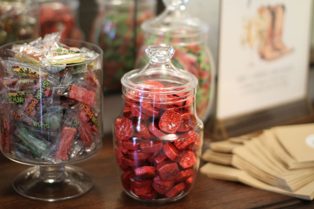 Glass jars filled with fresh red strawberries displayed in a rustic kitchen setting.
