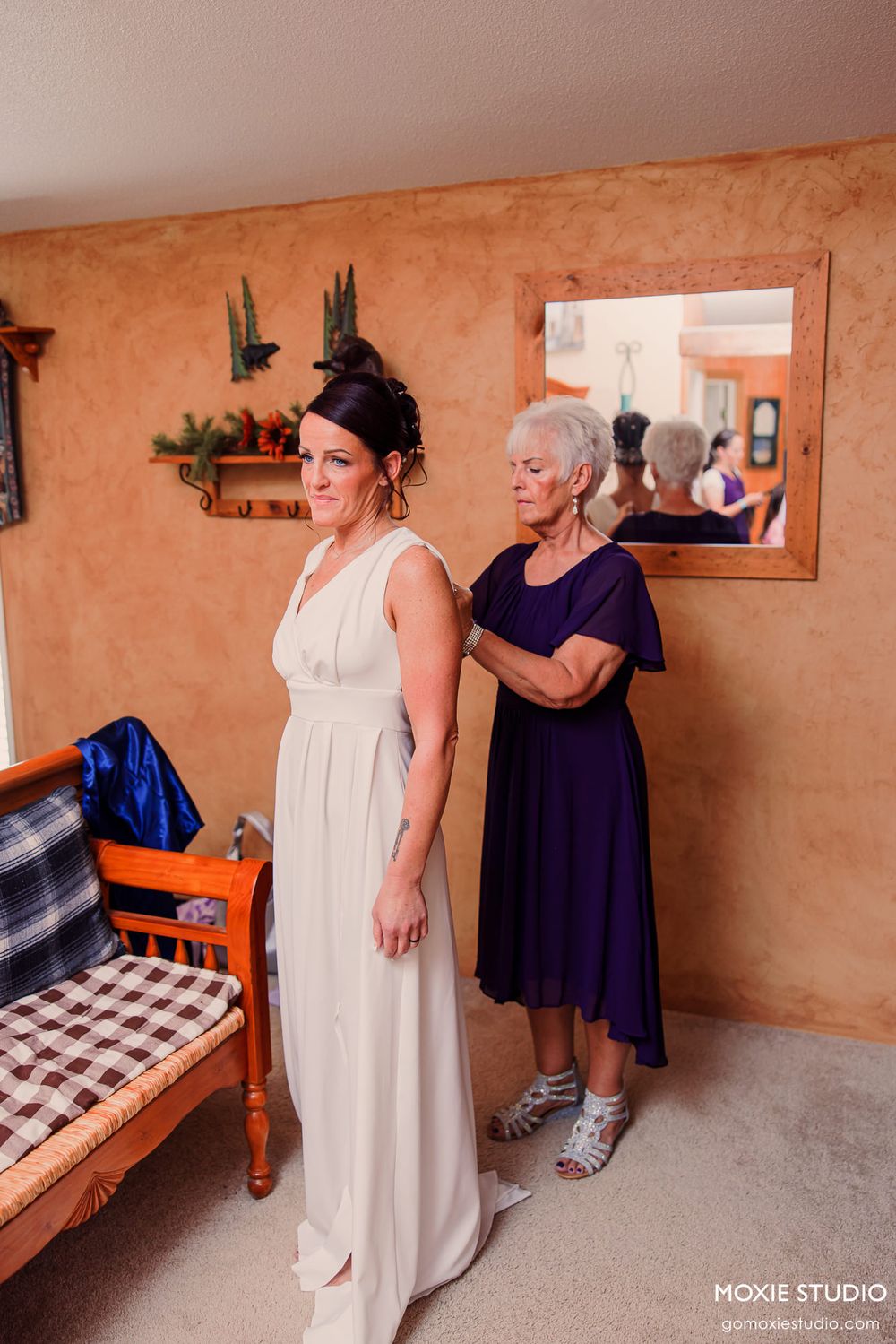 Wedding dress being fitted in room with terra cotta colored walls.
