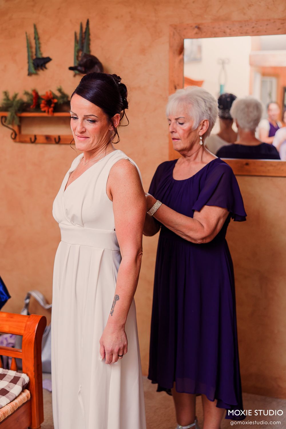 Wedding dress preparations taking place in room with orange walls.