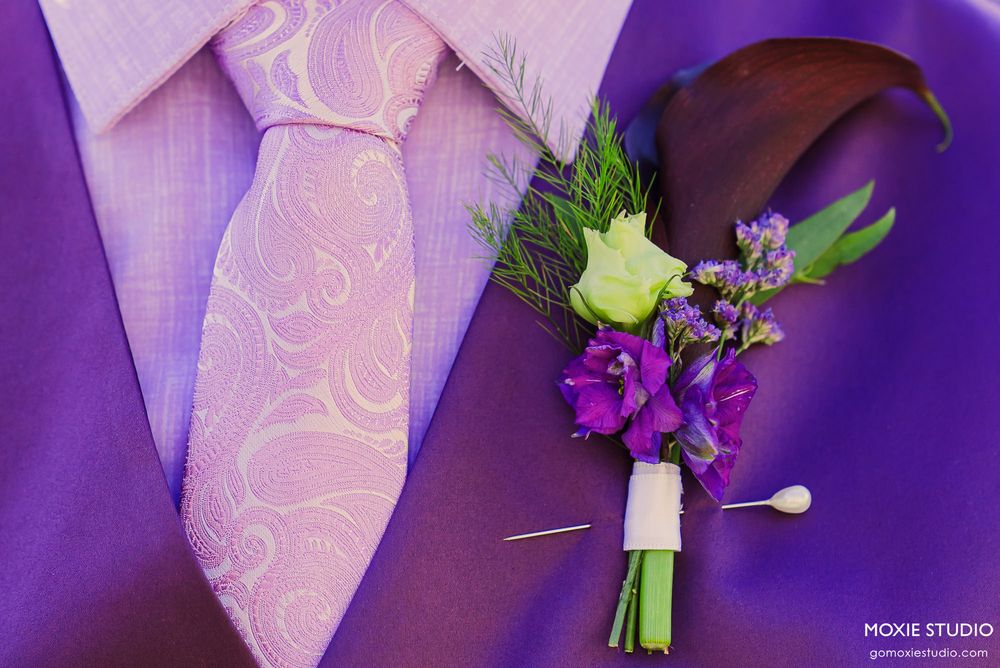 Close-up details of purple and pink floral wedding accessories and boutonnieres.