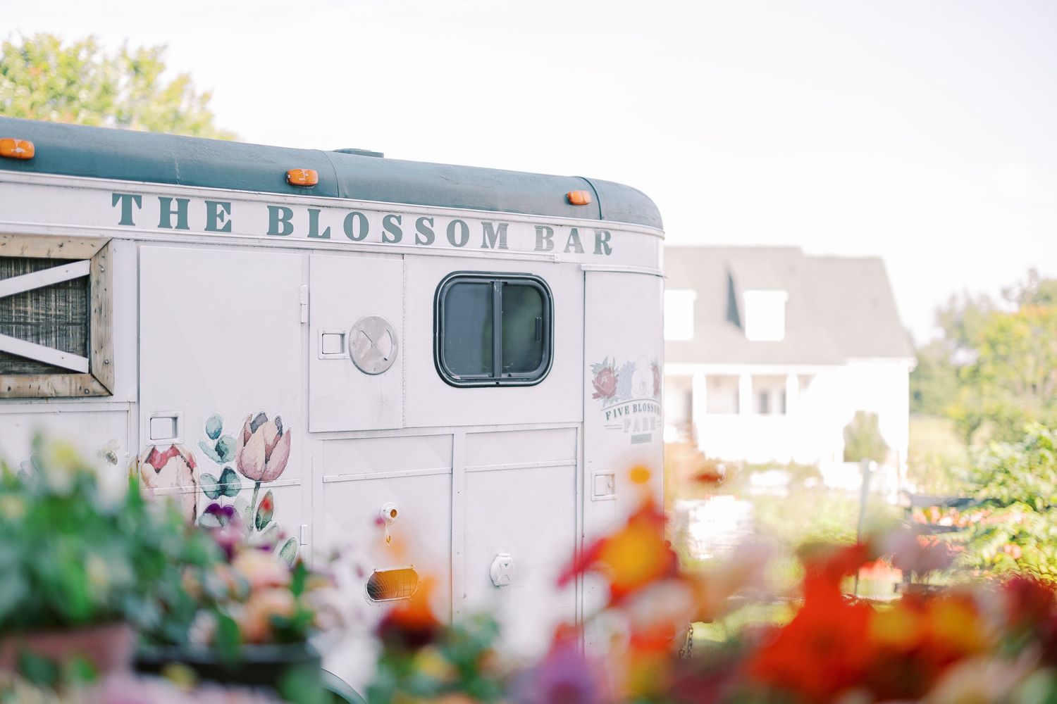 The Blossom Bar mobile truck parked with colorful flowers in foreground.