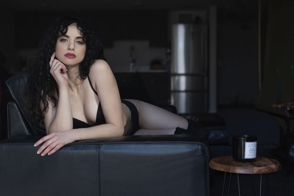 A series of moody boudoir photographs in dark tones showing a figure posing against dramatic lighting.