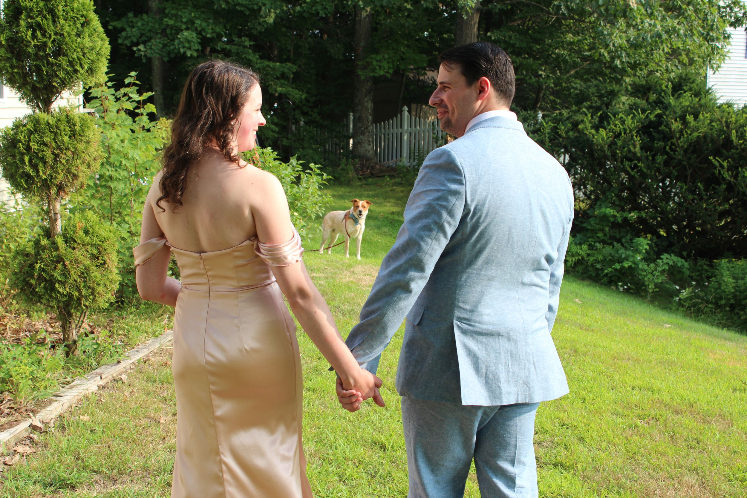 Candid photo of married couple with their pet dog during wedding photo session.