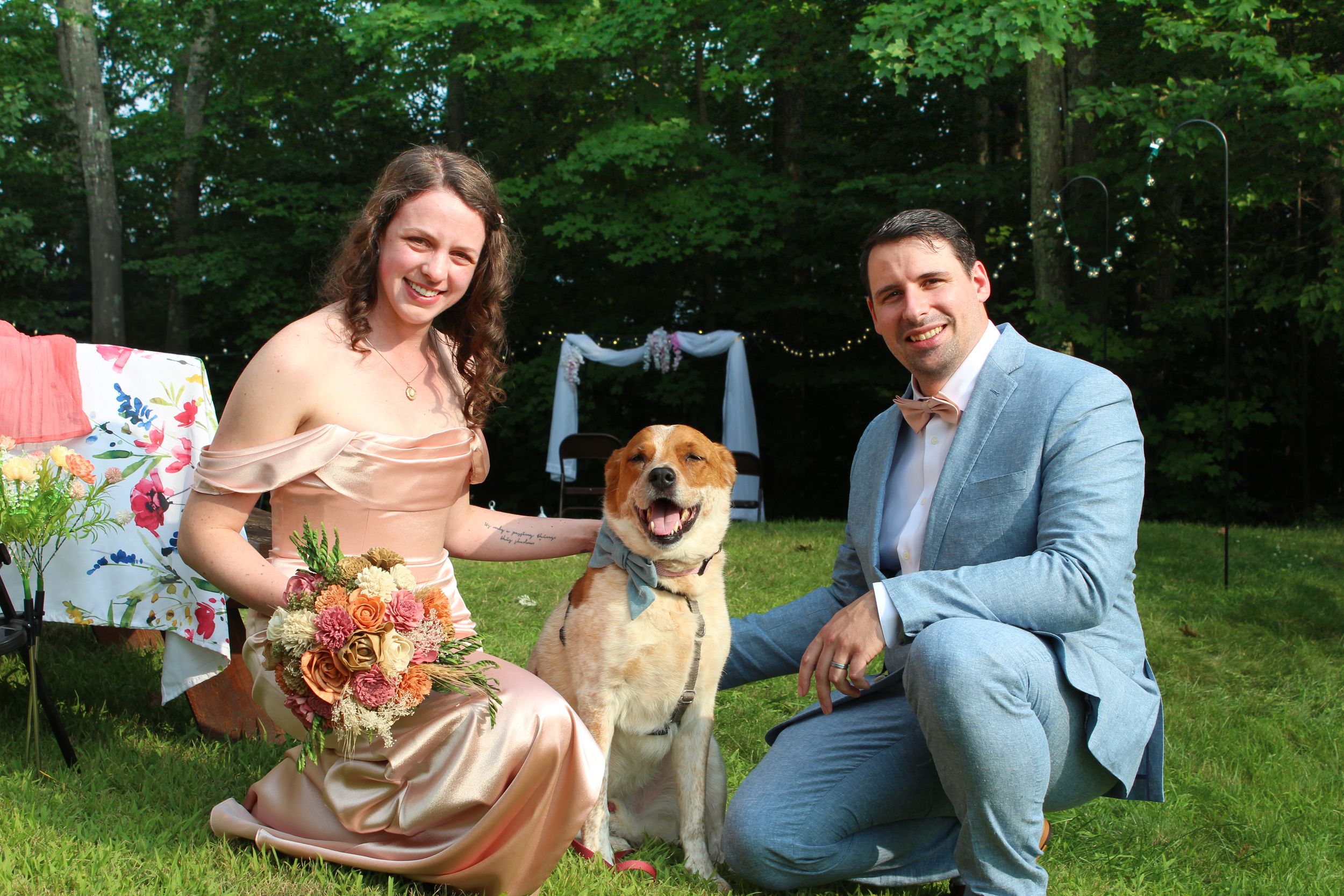 Married couple poses with their pet dog during wedding photo session.