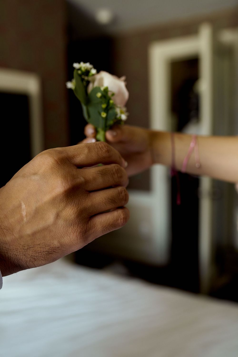Hand holding a small white flower against a light background in a sequential motion captured series.