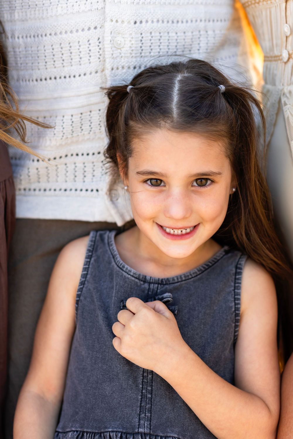 A child wearing a denim sleeveless top shows various candid expressions in a series of portrait photographs.