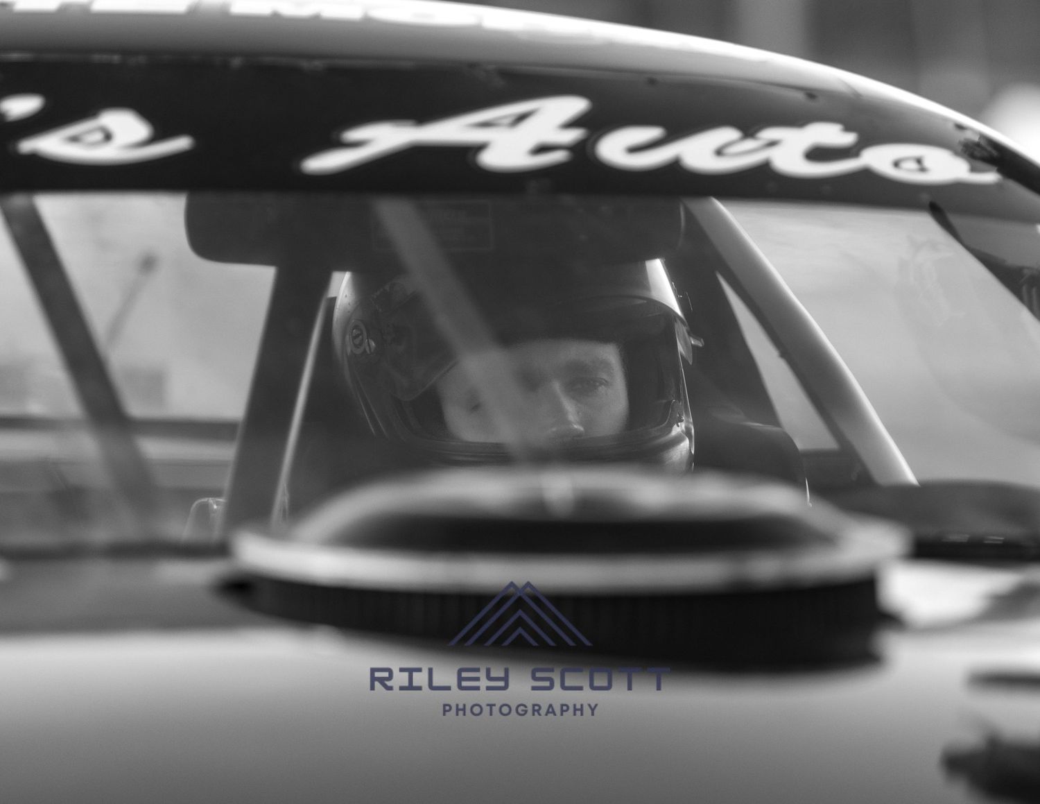 Black and white vintage car detail showing sleek chrome trim and curved bodywork details.