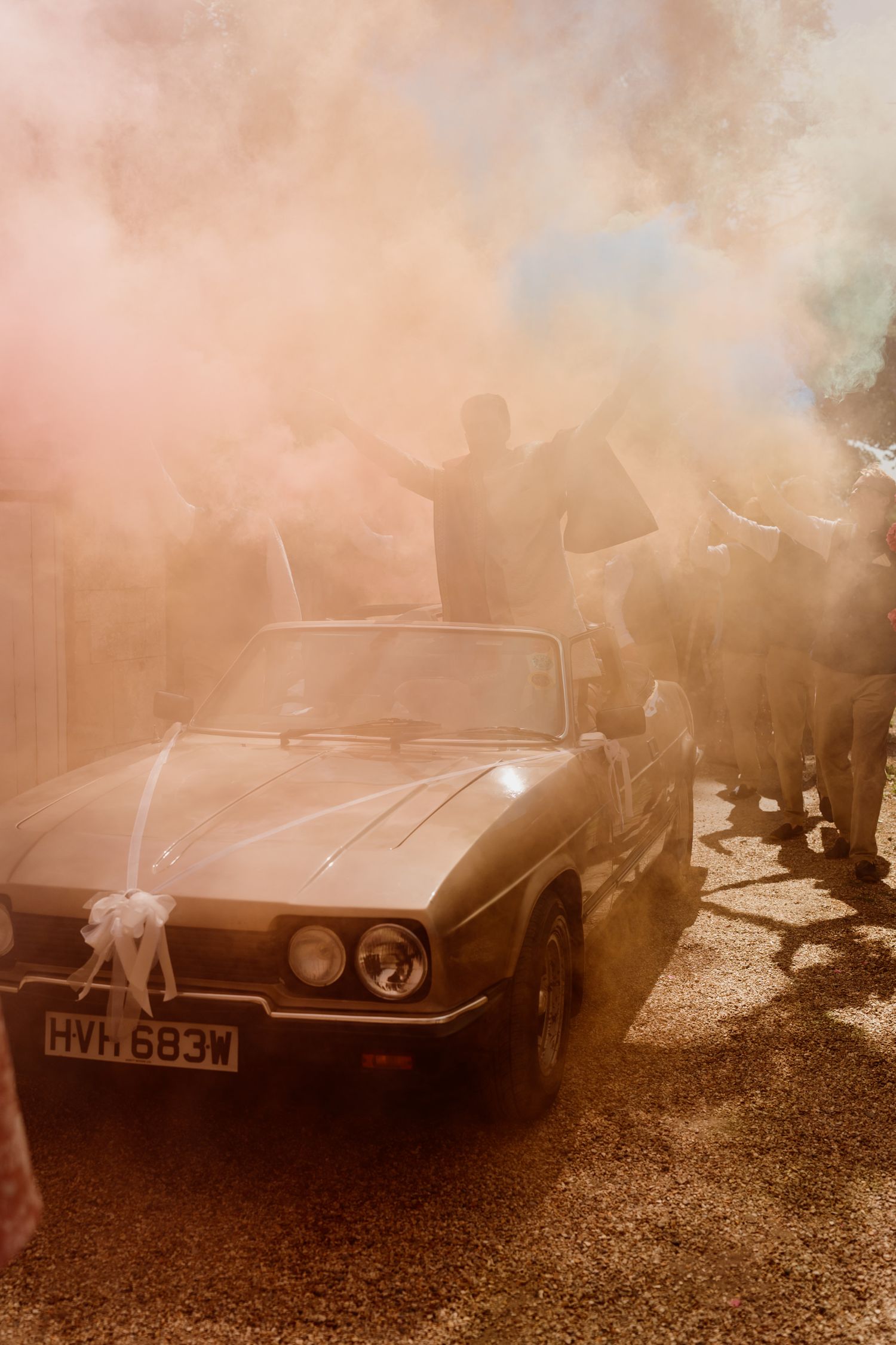 Classic sports car in sepia tones with atmospheric fog or smoke creating a moody vintage atmosphere.