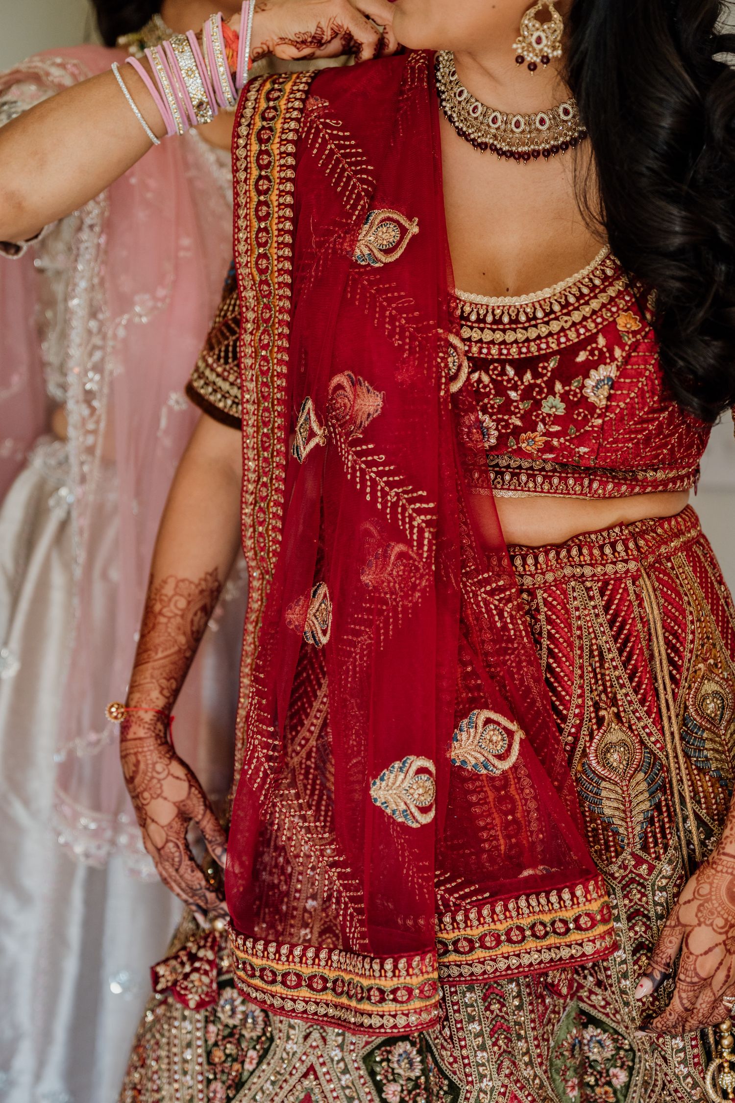 Intricate details of a red and gold Indian bridal lehenga with elaborate beadwork and embroidery.
