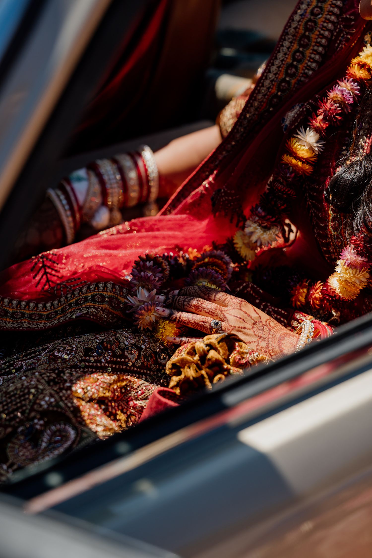 Traditional Indian bridal jewelry and red fabric details captured in dramatic lighting.
