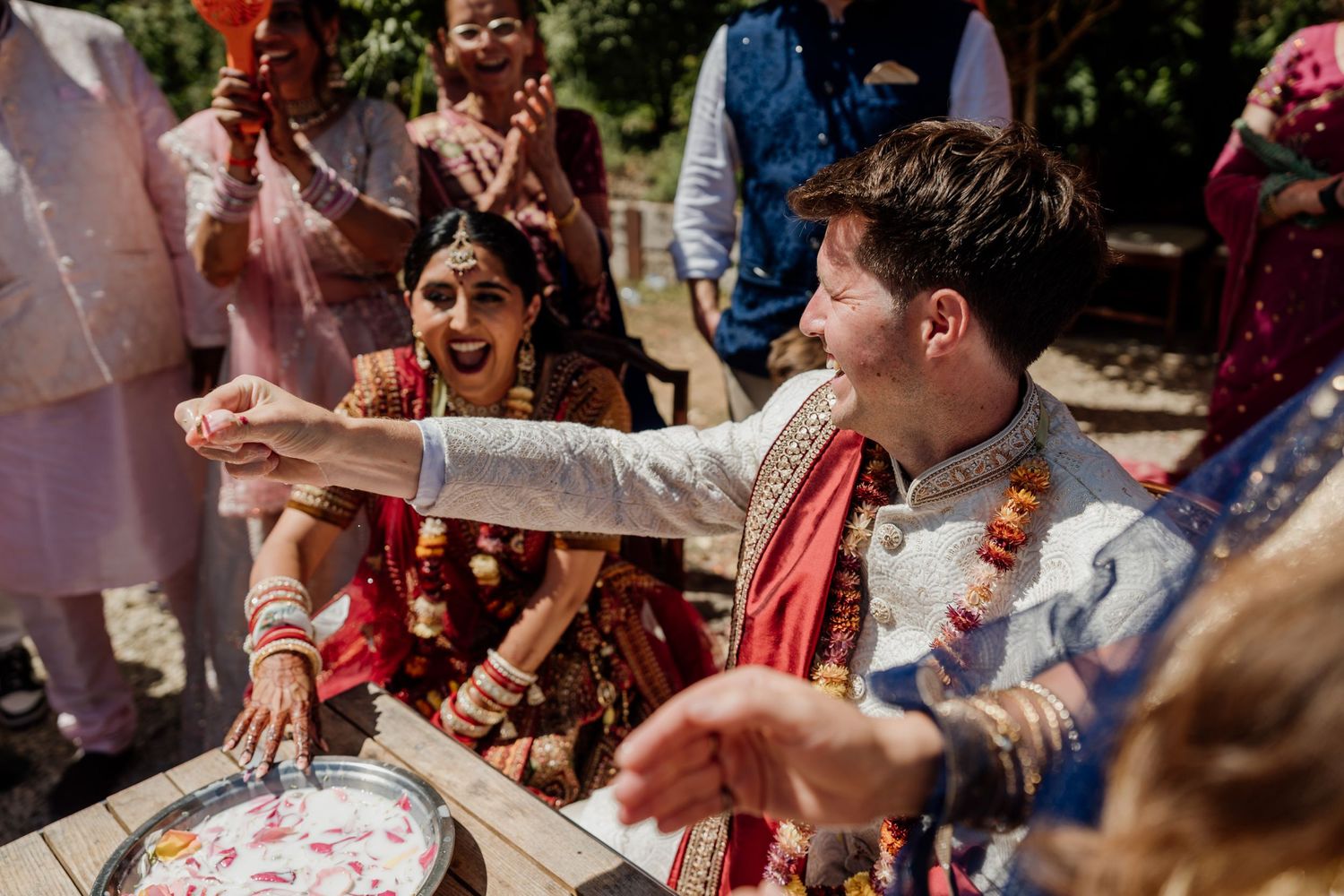 Wedding guests gather outdoors for a celebratory moment with confetti and festivities.