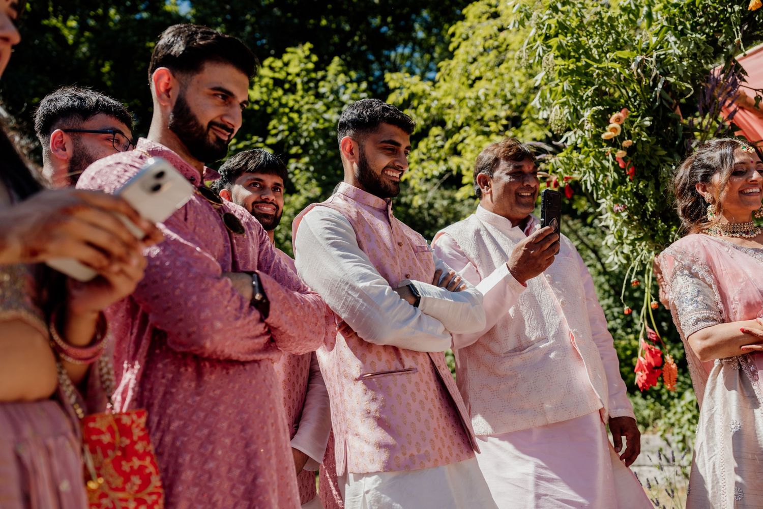 Wedding guests celebrating outdoors on sunny day with musical instruments.