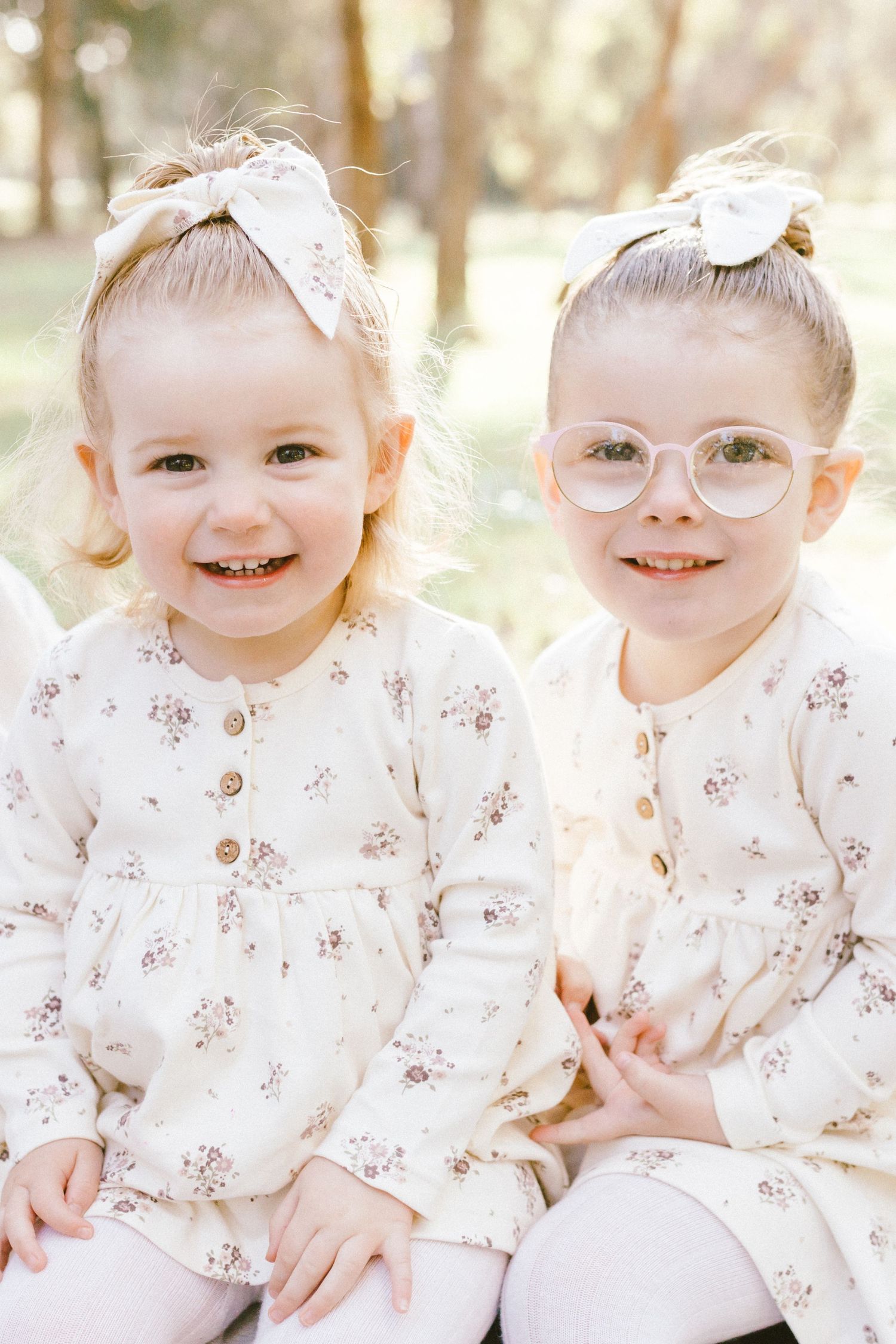A sequence of sweet expressions in white flowered dress and bow against a soft natural background.