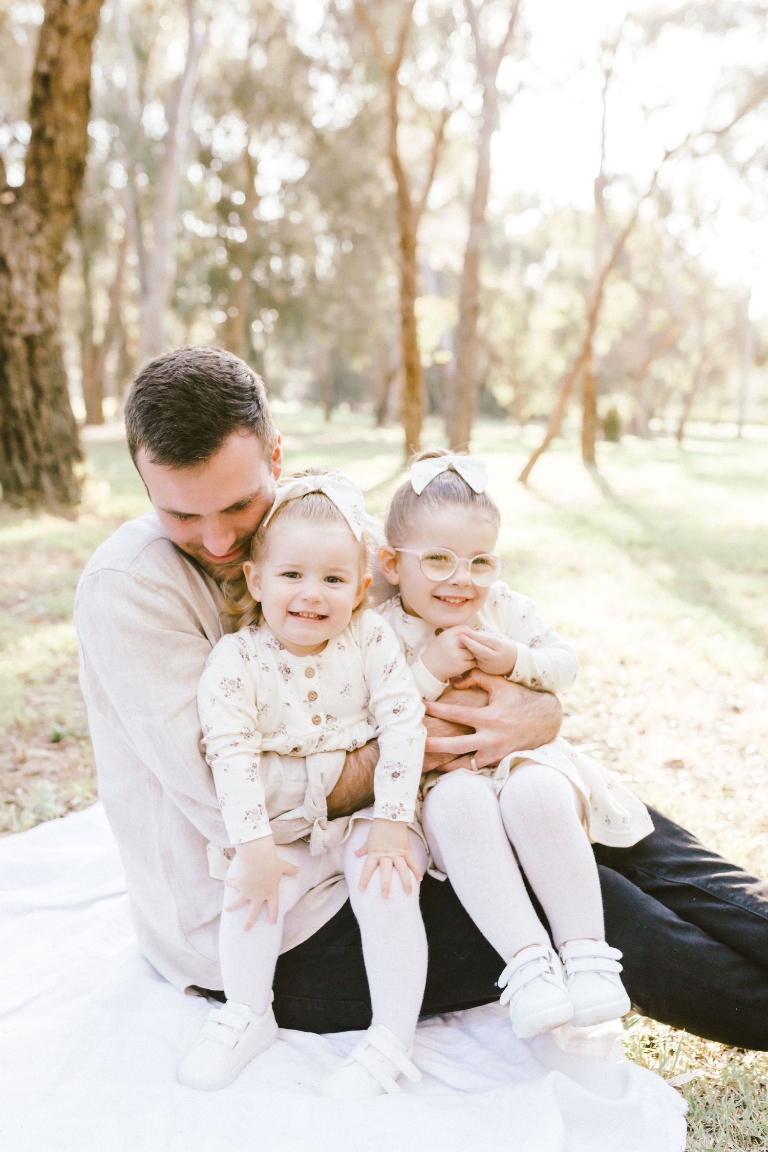 A loving family moment captured in a series of candid photos outdoors with soft natural lighting in a wooded setting.