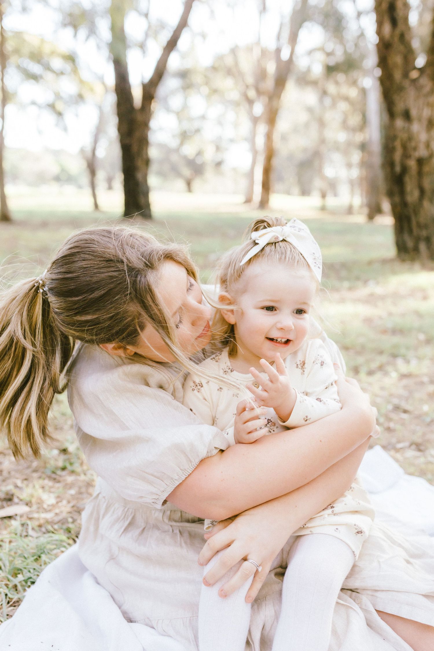 Candid photos capturing joyful embraces and playful moments together in a sun-dappled forest setting.