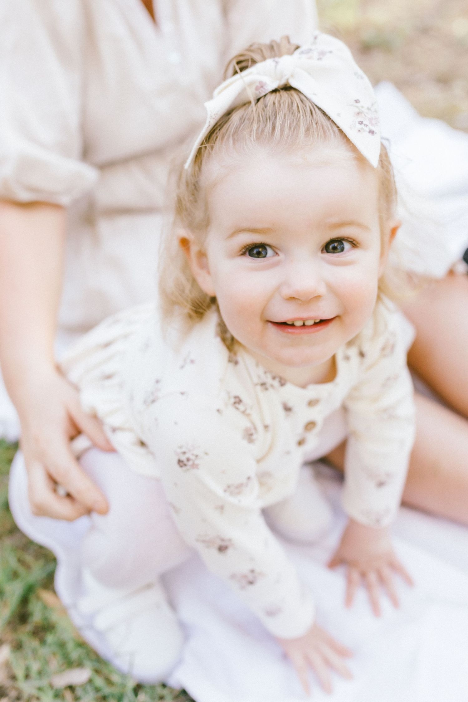 Close-up shots highlighting sweet expressions and delicate white lace details in a natural outdoor setting.