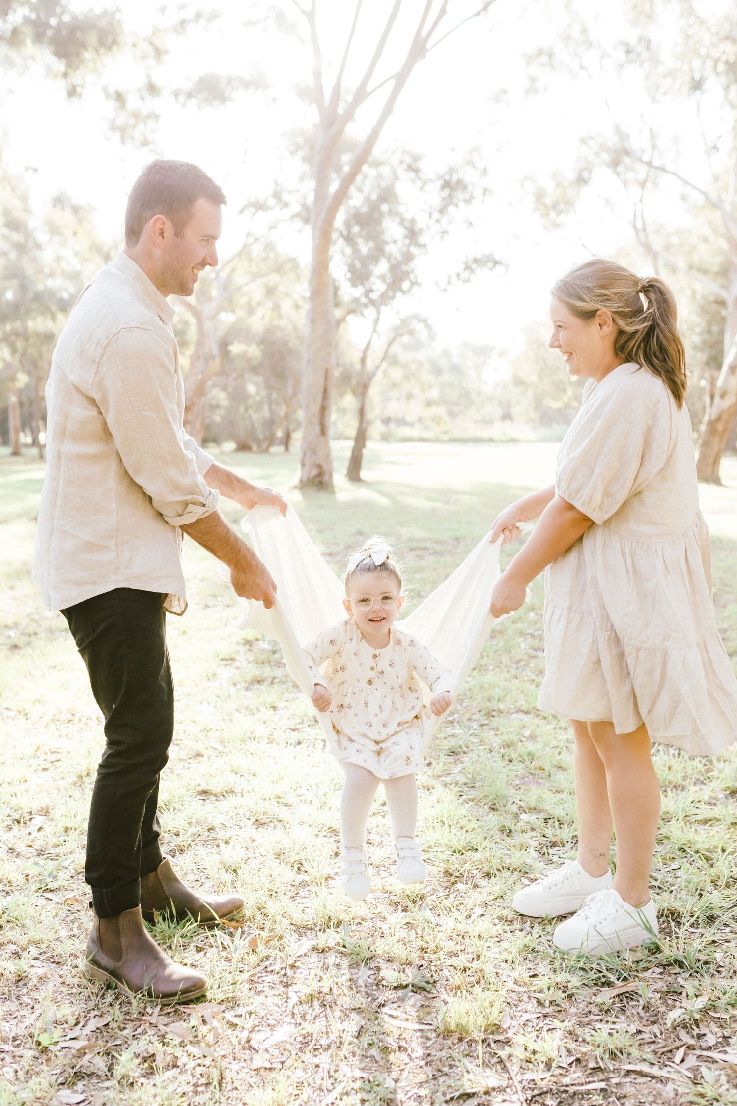 Candid family playtime shots in a park showing playful interaction and movement.