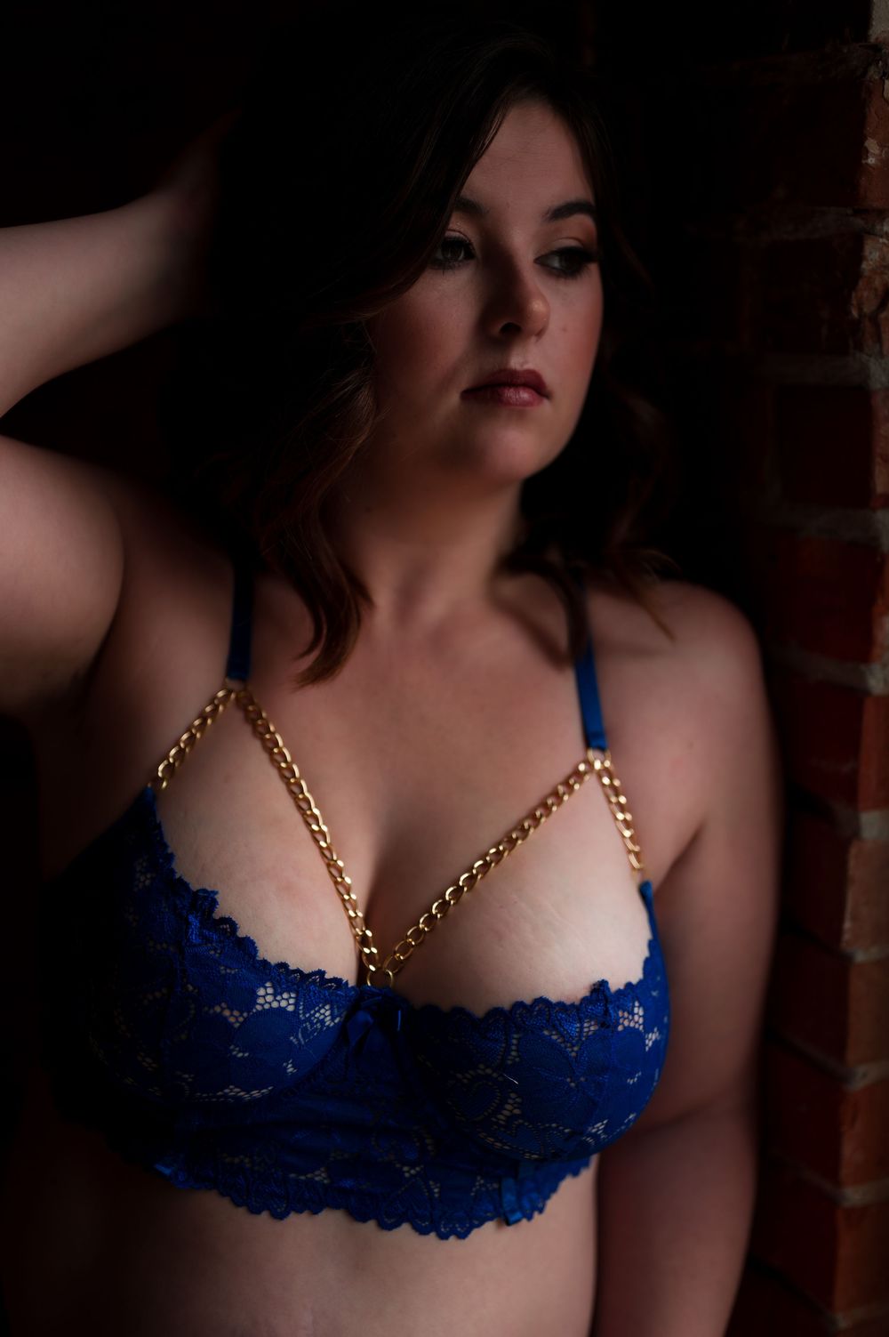 Gold necklace with blue lace bra shown in multiple angles with soft lighting and moody atmosphere.