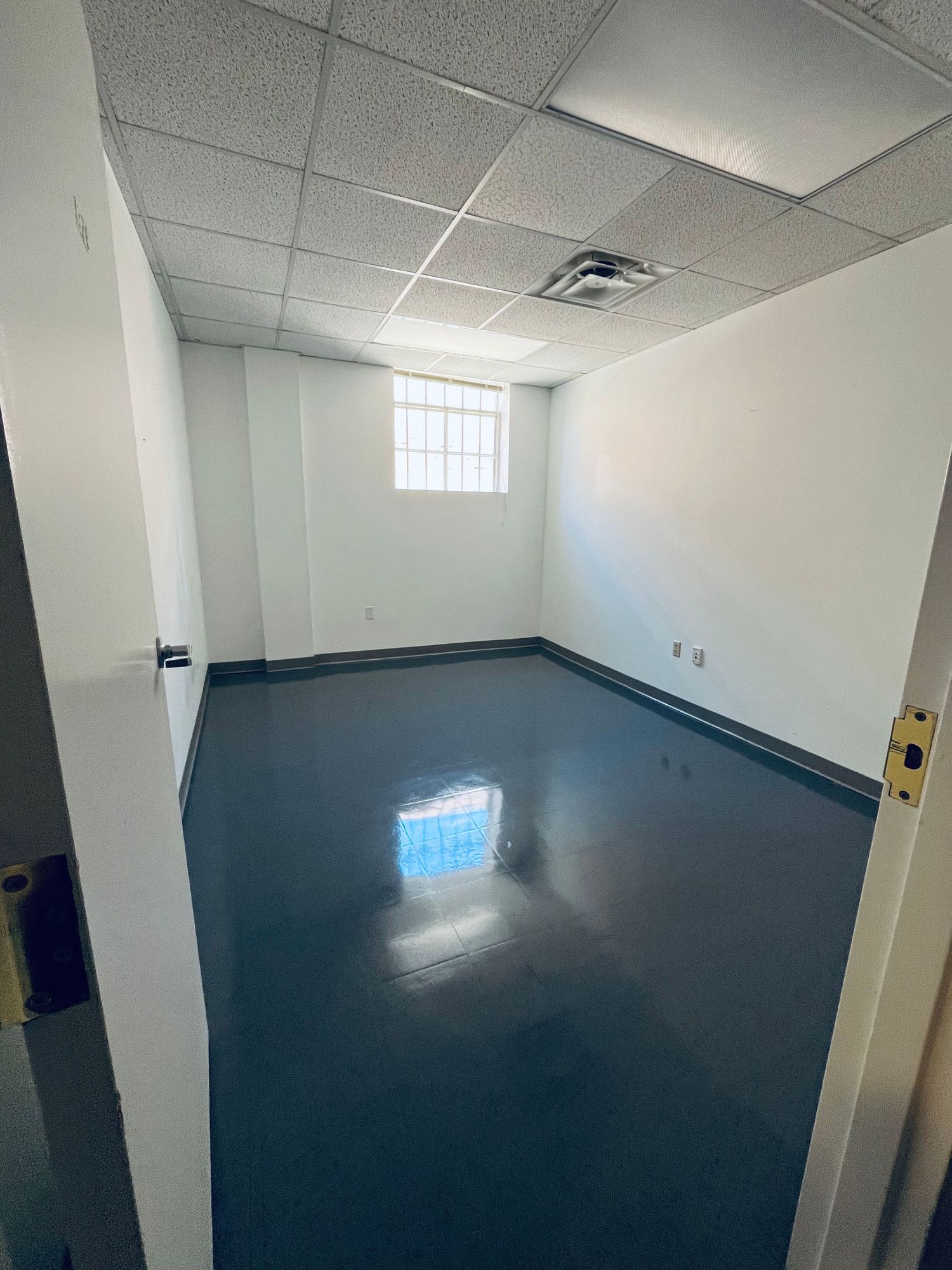 Construction site showing multiple views of a dark flooring installation in progress inside a commercial space with white walls.