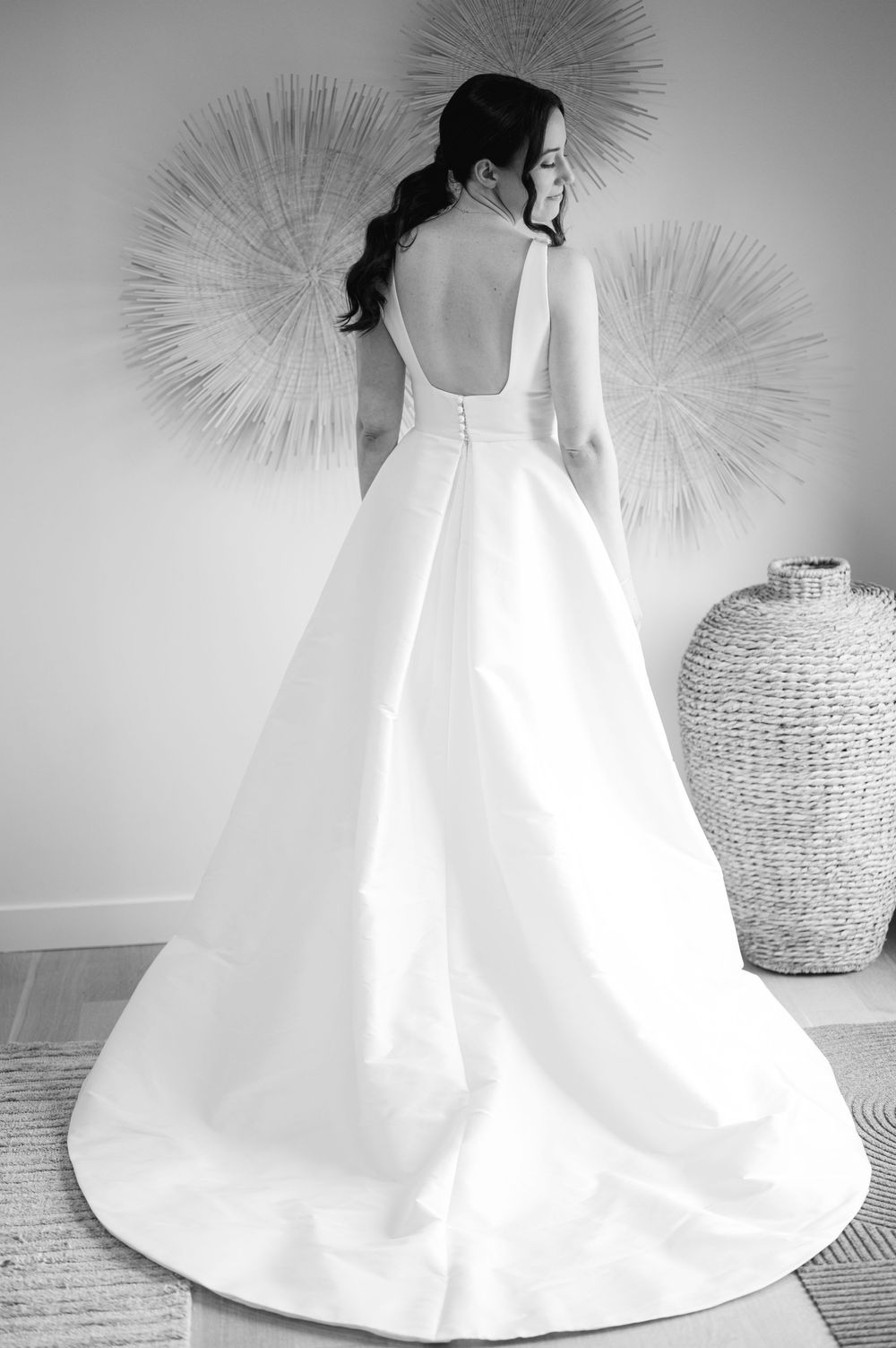 A black and white photo of a bride in a stunning white A-line wedding dress in the bridal suite of the Lakehouse in Halifax, MA