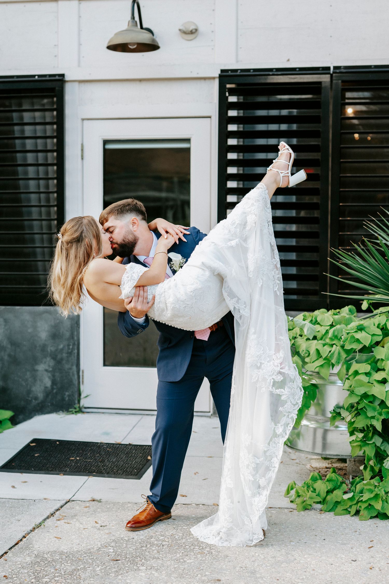 A series of artistic wedding dip poses captured in front of a modern building.