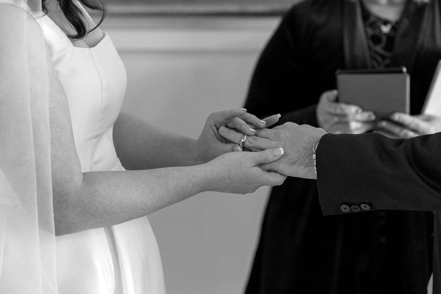 A close up Black and white photo of a Bride and Groom while exchanging their wedding rings in their Ceremony at La Maison Wodonga.