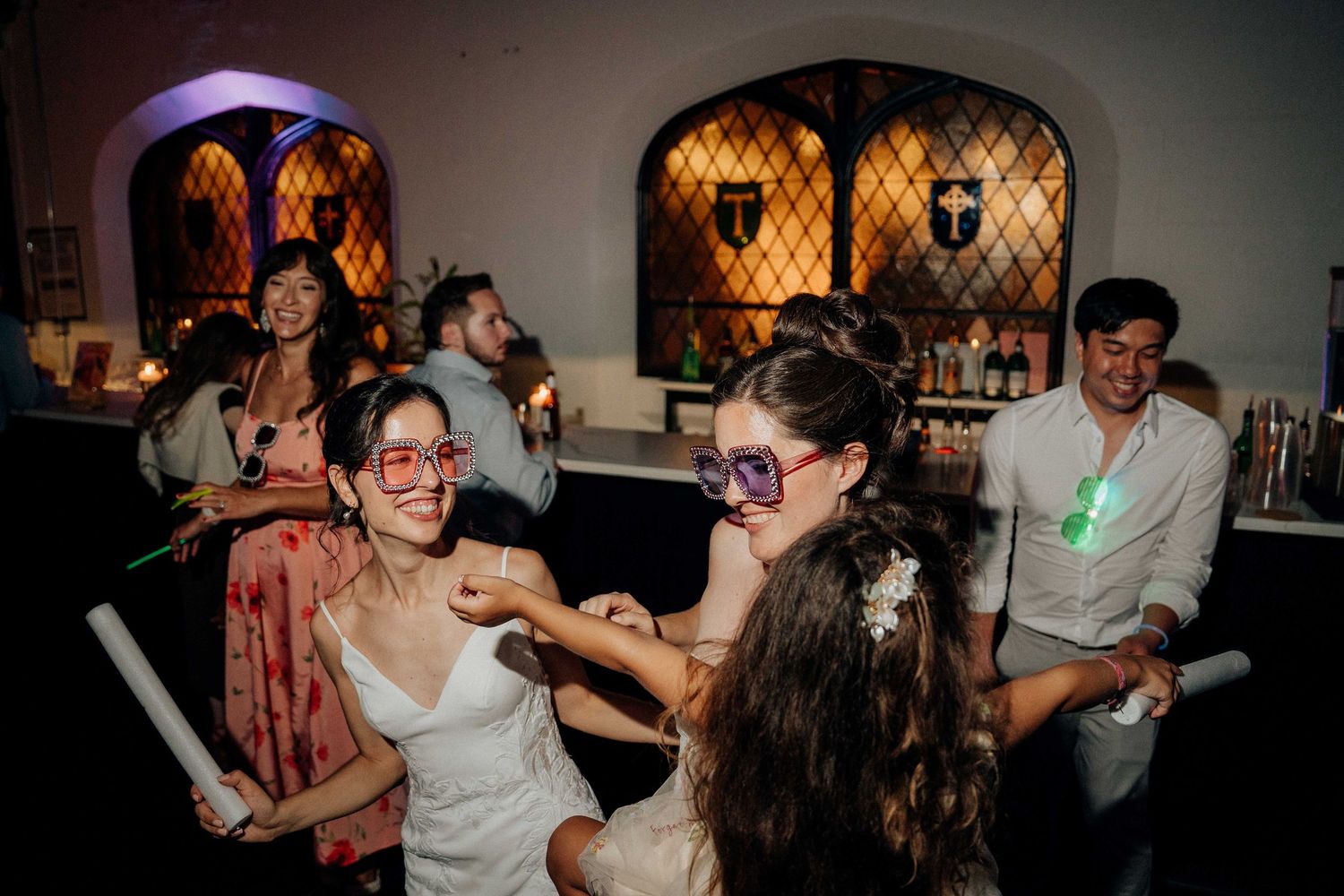 People enjoying a lively dance party in a dimly lit venue with warm lighting at the Sanctuary Roosevelt Island NYC