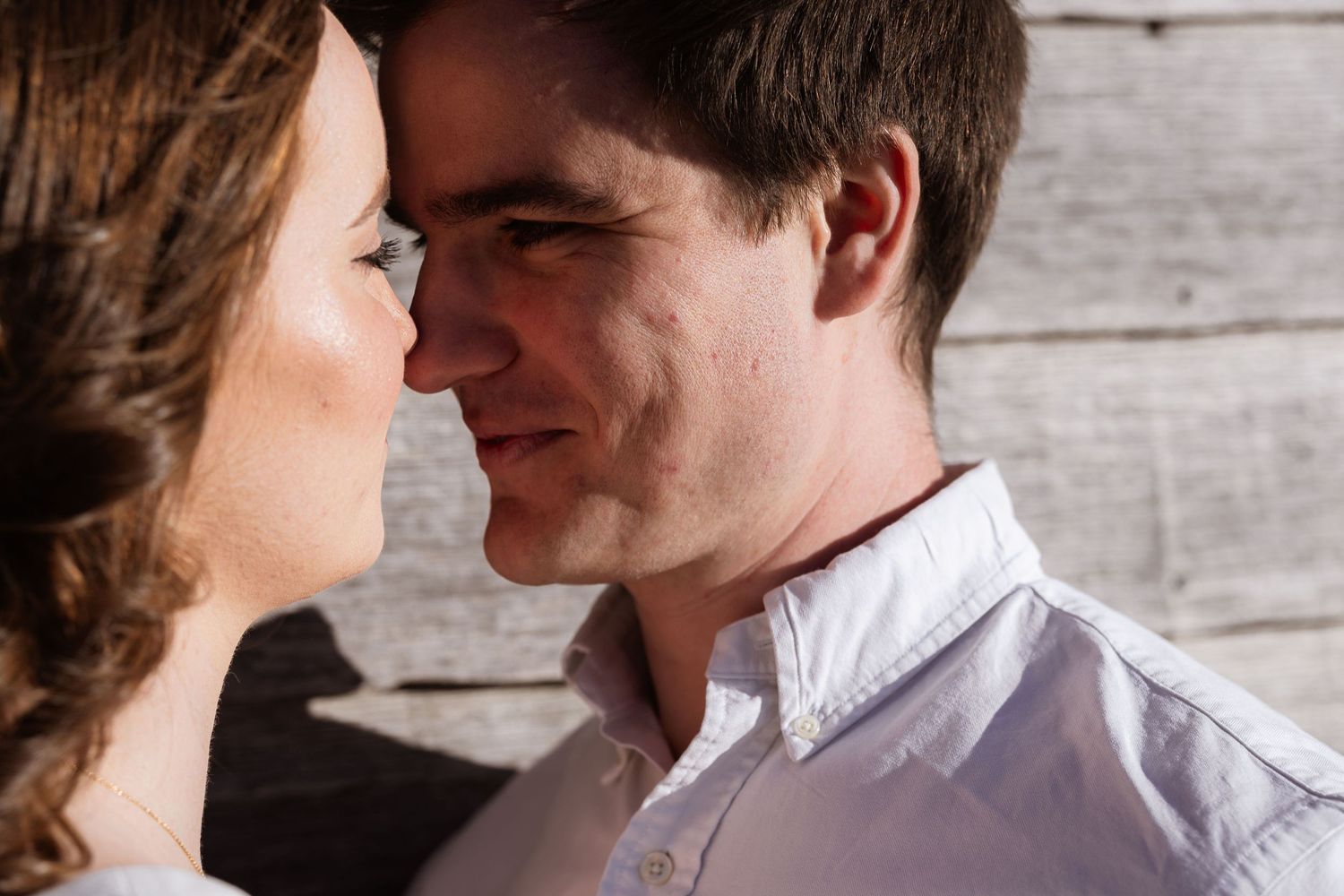 A couple embraces intimately across six connected photos showing romantic closeness against a rustic wooden background.