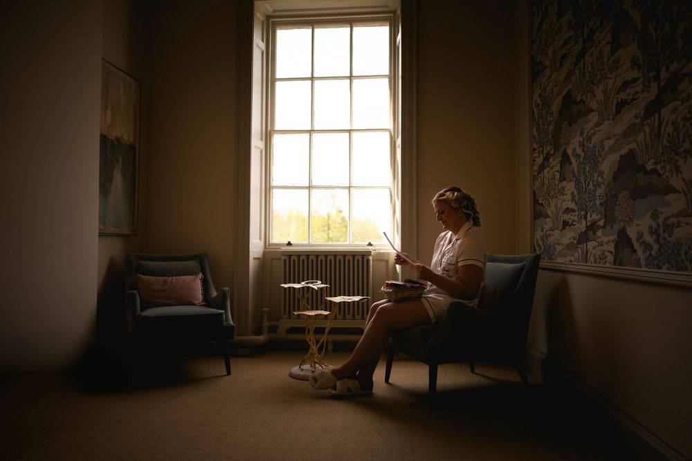 A moody black and white photo of a sunlit window creating dramatic shadows in a quiet room.