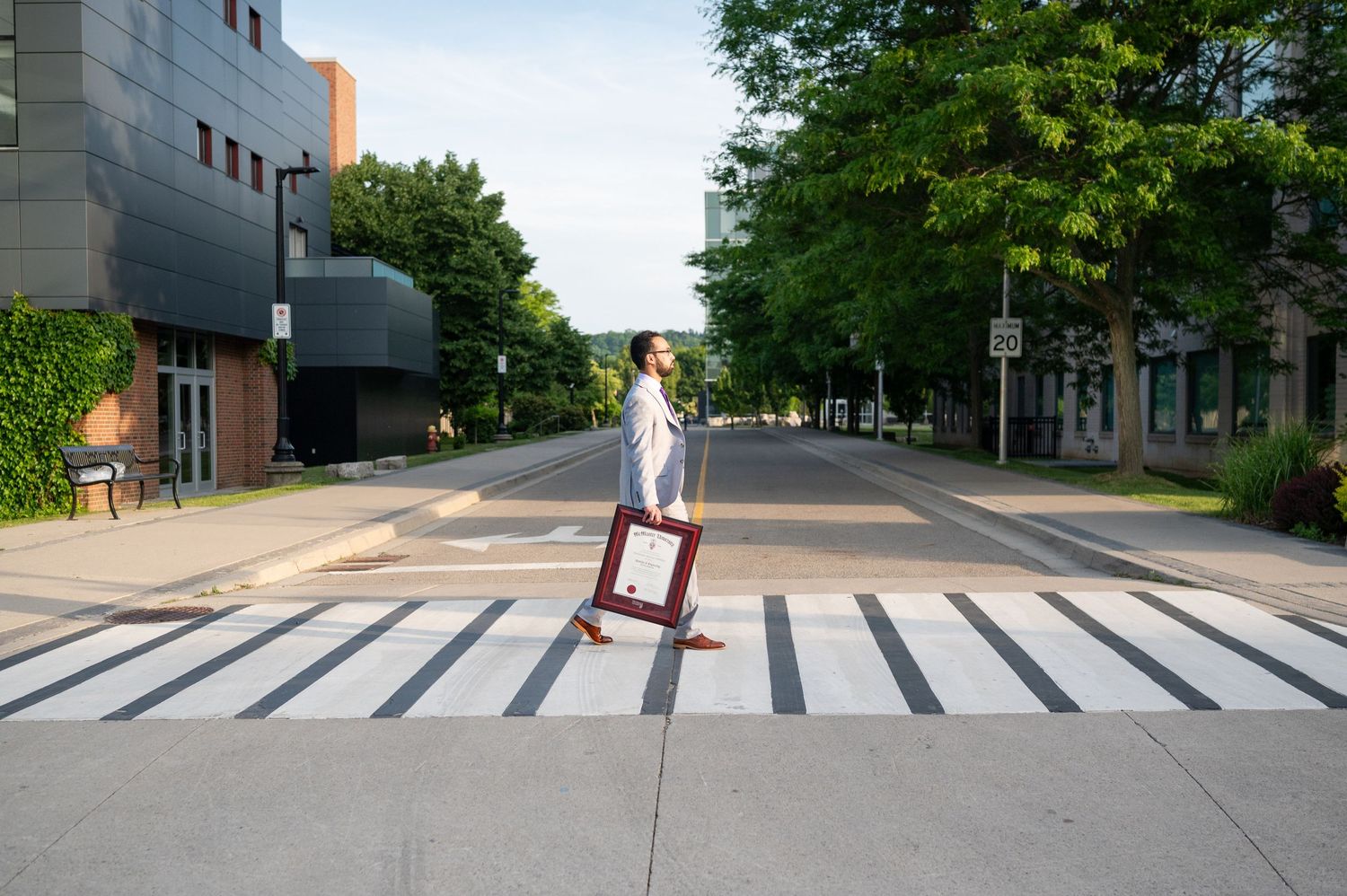 Wide urban street view with striped crosswalk and modern buildings in daylight.